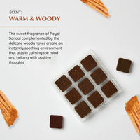 Brown square candles in a clear container with text about their scent on a light background
