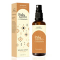 A bottle of Aromafume Palo Santo & Cinnamon Smudge Spray with a spray nozzle, next to its packaging box which has a geometric pattern.