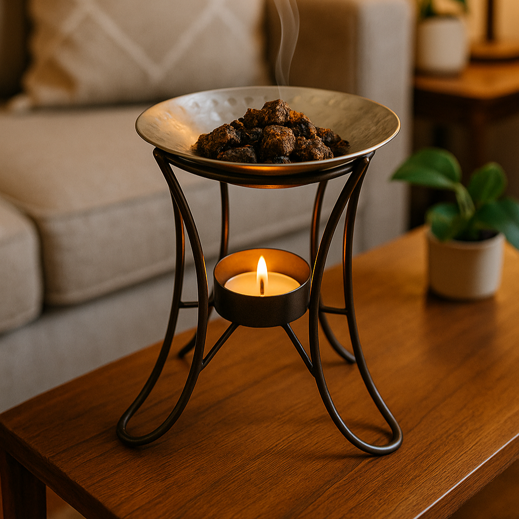 A small metal bowl with smoking incense on a wooden table in a living room.