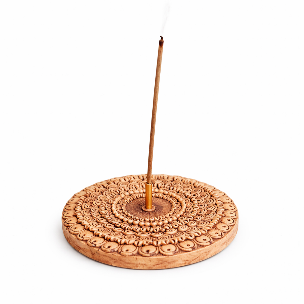 Decorative clay finish mandala  incense holder with a single incense stick on a white background