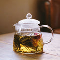 Glass teapot brewing Mucuna tea on a wooden table