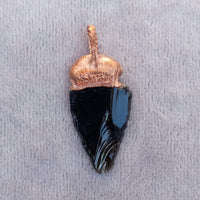 Detailed view of an obsidian arrowhead pendant