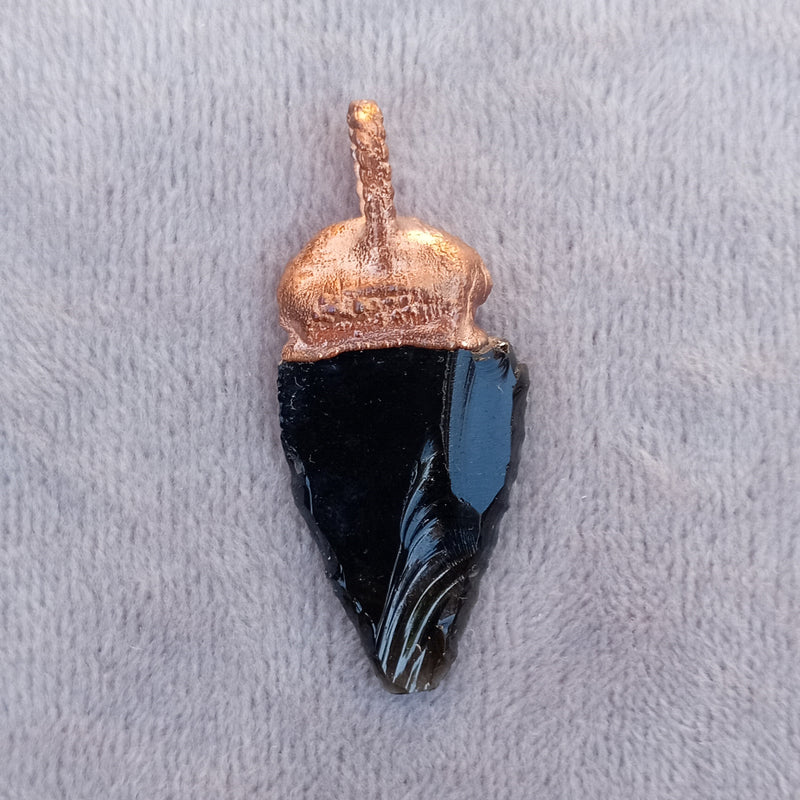 Detailed view of an obsidian arrowhead pendant