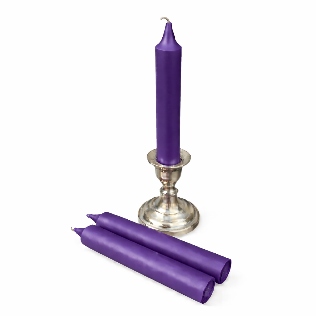 Purple ritual candle and two candles on a white background