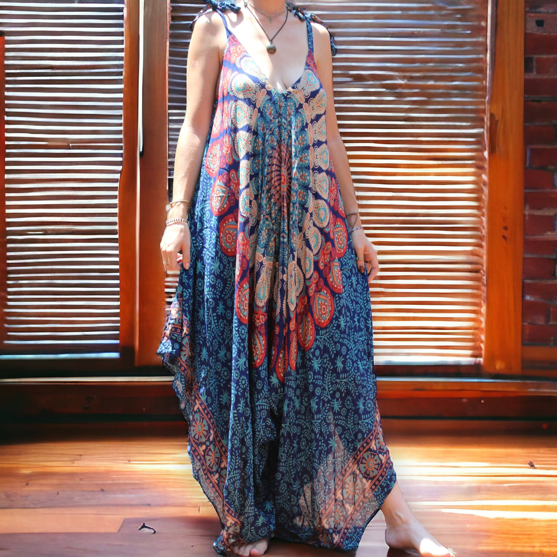 Model wearing Secret Sense Serenity Strap Jumpsuit in blue with mantra pattern