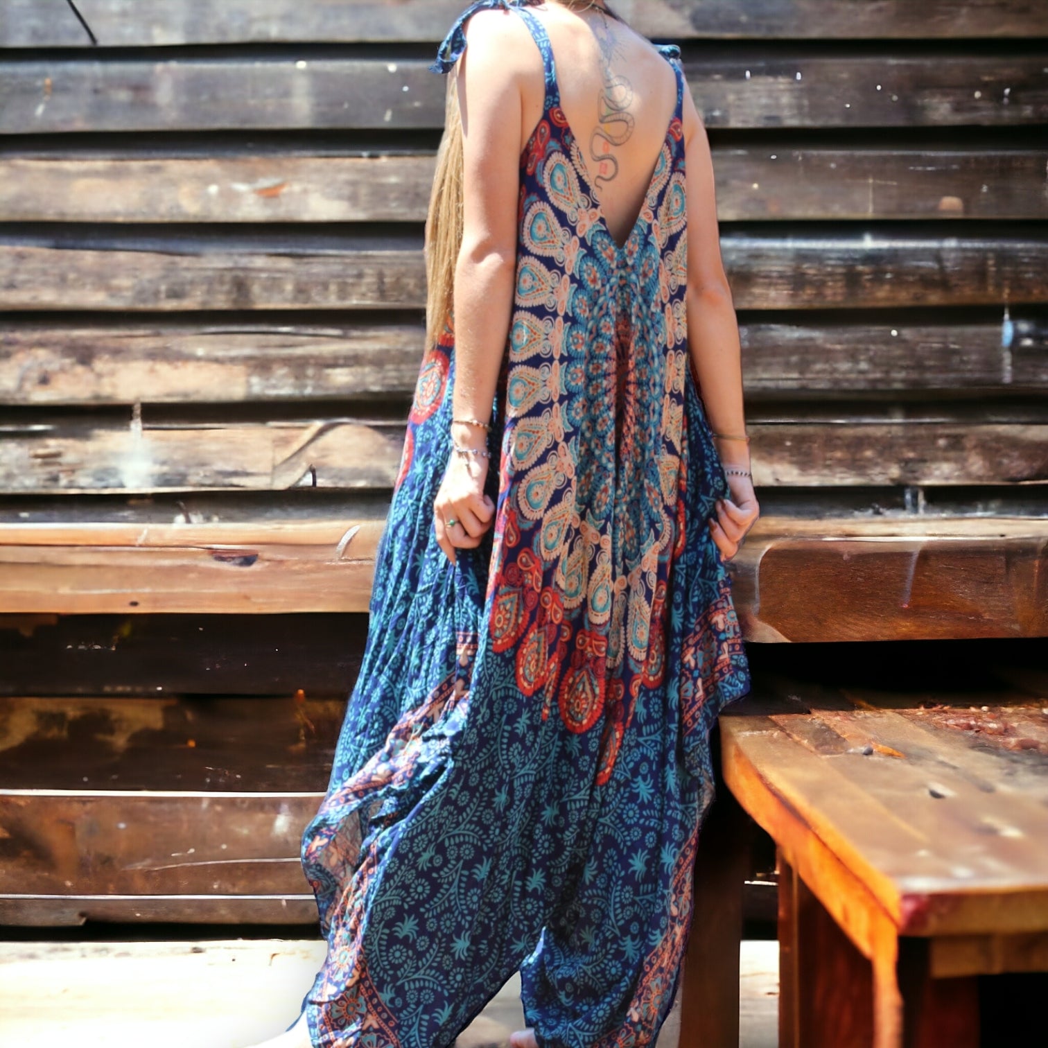 Model wearing Secret Sense Serenity Strap Jumpsuit in blue with mantra pattern