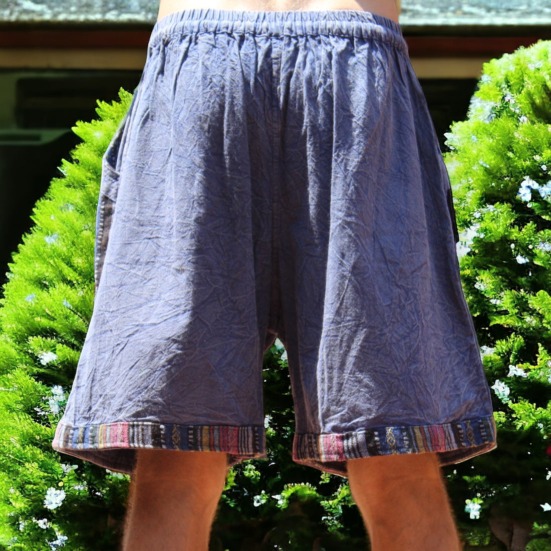 Man in Secret Sense Nomadic Spirit Boho Shorts amidst vibrant greenery