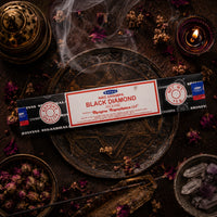 Nag Champa Black Diamond incense packaging with smoking incense sticks on a dark background.