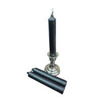 Black candle and candle holder on a white background