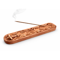 Decorative wooden incense holder with incense stick on a white background