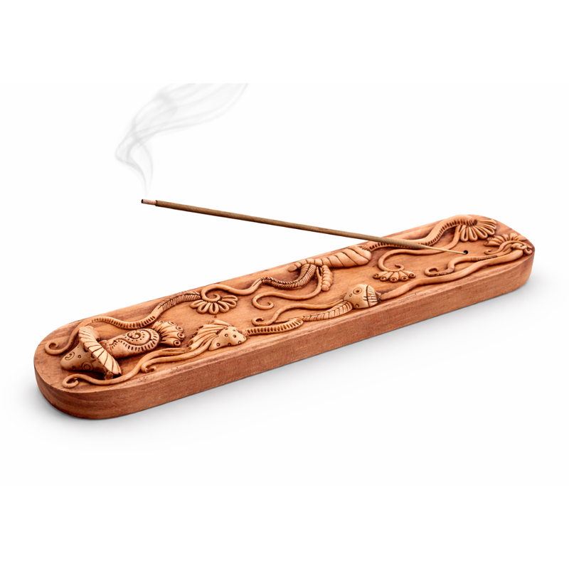Decorative wooden incense holder with incense stick on a white background