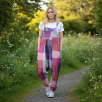 Woman wearing a colorful checkered boho style dungaree walking on a path surrounded by nature.