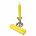 Yellow ritual candles with a silver candle holder on a white background