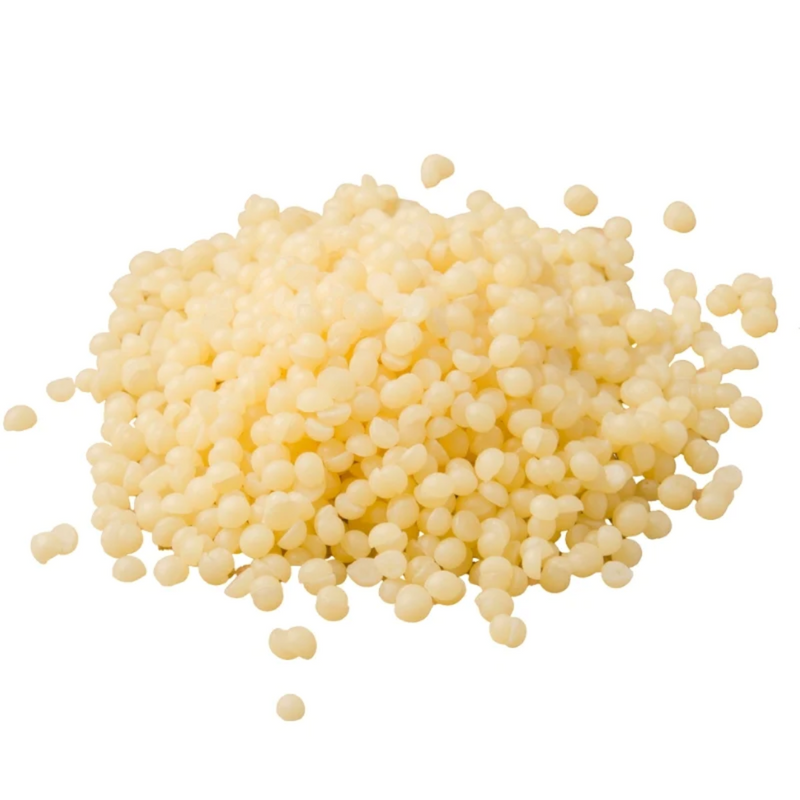Close-up of natural beeswax pellets — eco-friendly craft wax with smooth honey tone and soft texture.